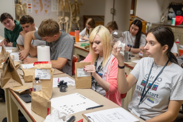 Incoming first-year college students analyze crime kits in a lab