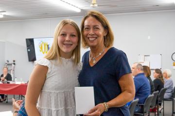A woman poses with a teenager at an event