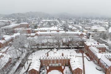 The East Green is shown covered in snow, with the city of Athens in the background in this aerial image