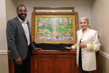 A man and a woman standing next to a painting.