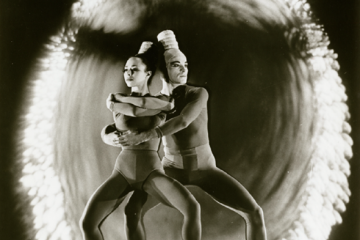 Two individuals are shown dancing in this black and white image