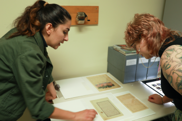 Two individuals look over part of the Founders Day exhibit