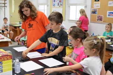 students in a Kids in College STEM class make animal footprints with stamps