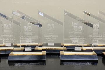 A group of glass awards lined up