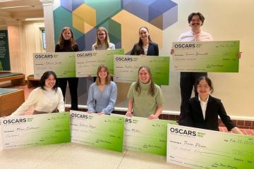 The finalists in the OSCARS Impact Competition pose  with giant checks showing their awards