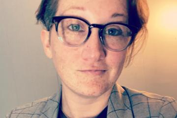 Headshot of woman with short hair, glasses, Blazer