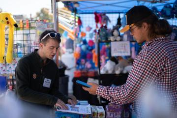 Ohio University student Bozeman Koonce asks a vendor a series of research questions at the Circleville Pumpkin Show.