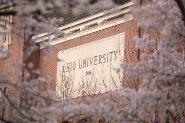 Cherry blossoms bloom on trees near the Ohio University sign at Peden Stadium