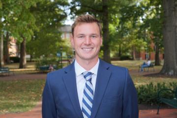 A headshot of a man in a suit.