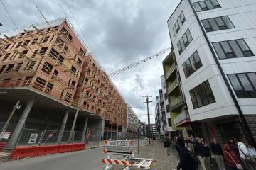 Two buildings with a street between them against a cloudy sky.