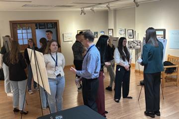 Students, faculty and staff look over the poster presentations at the AURCO Conference