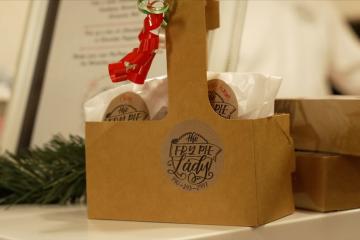 an image of a paper bag on a decorated table, and the bag says The Fry Pie Lady - 740-243-2447
