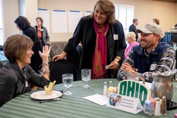 OHIO community members speak together while gathered around a table at the Community Engagement Symposium