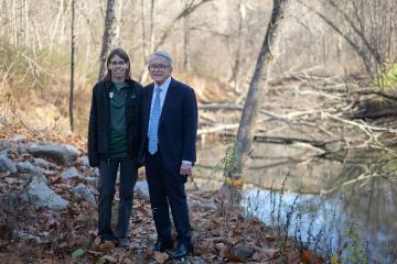OHIO Governor Mike DeWine and a member of the Raccoon Creek Partnership stand beside Raccoon Creek