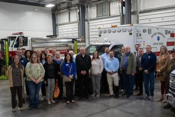 Members of the Mayors' Partnership for Progress pose for a group photo next to fire and rescue trucks
