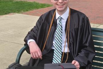 Seth Southers sits in front of Bennett Hall