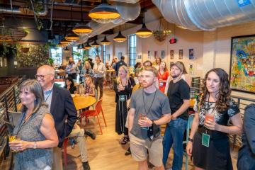 audience members listen to speakers at the anniversary event at Jackie O's