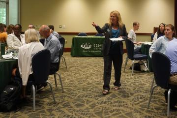 Dr. Haley Duschinski walks among the crowd and leads a presentation