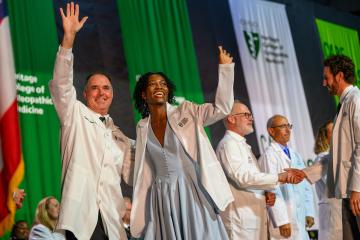 Executive Dean Ken Johnson and a student from the Class of 2029 wave to the crowd