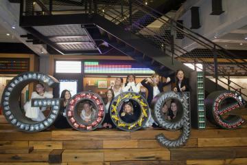 college students pose with a life-size Google logo statue