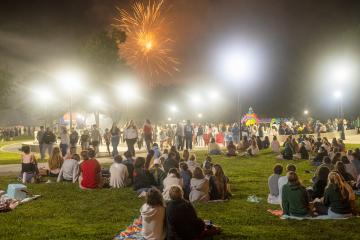Fireworks erupt over a field of spectators