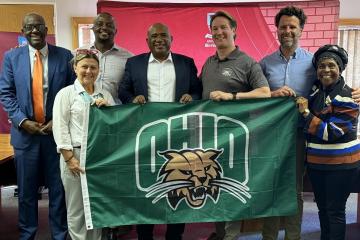 Representatives of Ohio University and the University of Botswana hold an OHIO flag while at the University of Botswana