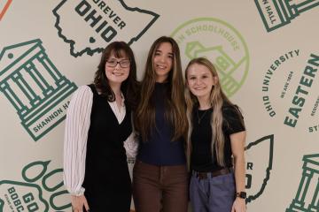 Three females standing next to each other, smiling