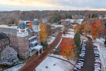The buildings and colorful fall trees at the Ridges are covered with a thin layer of snow