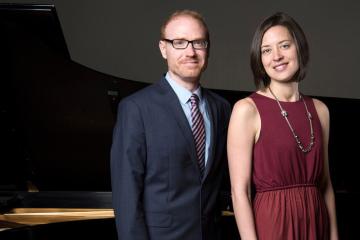 Christopher and Katherine Fisher pose in front of a grand piano