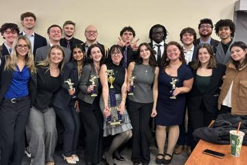 A group of students pose with trophies