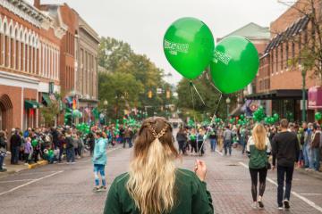 An OHIO student holds balloons on Court Street