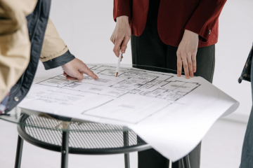 professionals looking at interior architecture blueprint on stool