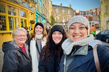 OHIO students and faculty member Teri Peasley stand together on a busy sidewalk in England
