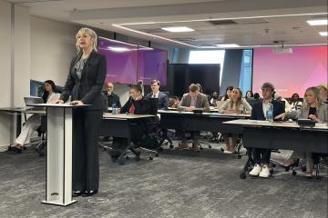 An OHIO student stands up and gives a professional presentation in front of other students and faculty