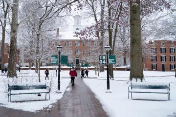Students walk on the brick paths on the snow-covered College Green