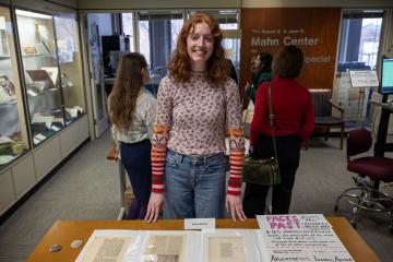 Someone smiling, showcasing their archives exhibit.