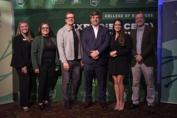 Representatives of the OHIO - LAIOB partnership stand together for a photo in front of an OHIO banner