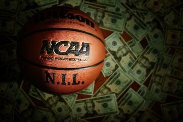 An NCAA basketball with the NIL written on it.