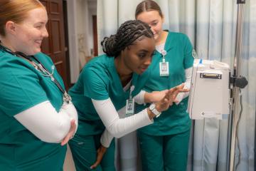 Three OHIO students work on equipment in a nursing lab on OHIO's Athens Campus