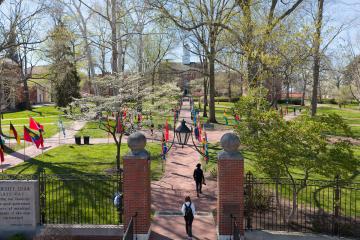 College Green is covered with international flags, while the trees are green and white on a spring day, in this image taken above from a drone