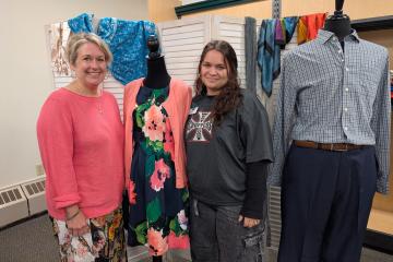Two women standing beside clothing display
