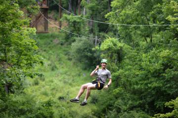 Cat Camp participant swings on zipline