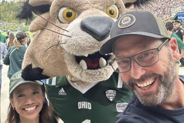 Gregg Patner stands with OHIO's Rufus mascot and another individual at an OHIO football game in Peden Stadium