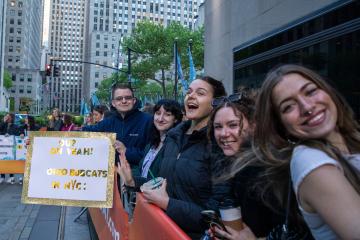 OHIO students wait outside and hold a sign that says "OU? Oh Yeah! OHIO Bobcats in NYC"