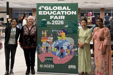 Four OHIO representatives stand in front of the Global Education Fair banner at one of the events