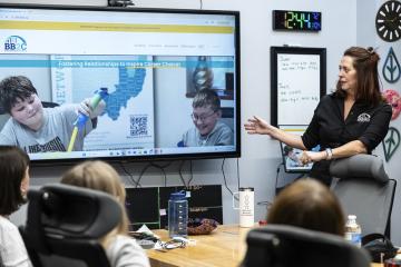 A BBC2 representative leads a presentation in front of a class