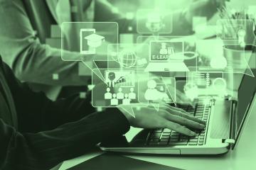 Hands type on a computer while graphic designs are shown above the computer
