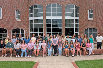 A group of students and faculty and staff stand outside of OHIO Southern