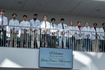 Students stand for a moment of silence during the Body Donor Memorial Service.