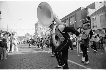 Marching 110 members perform on Court Street in this black and white image of a past Homecoming celebration at Ohio University